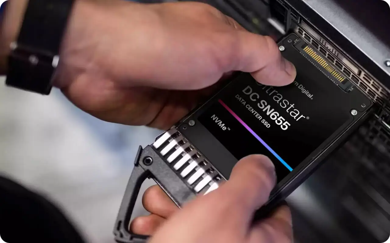 Main insérant un SSD NVMe Western Digital Ultrastar DC SN655 dans un serveur.